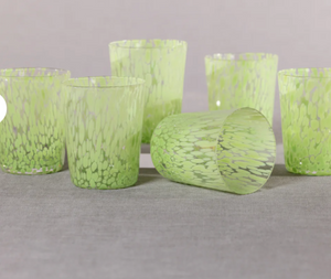 Set of green textured glass candle holders on a gray surface