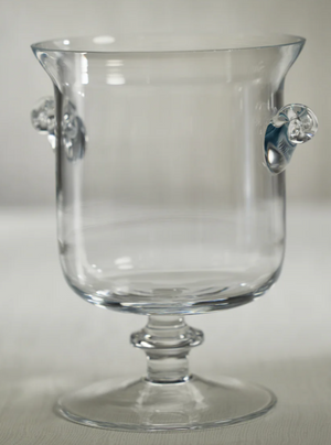 Clear glass goblet with decorative handles on a light gray background