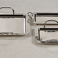 Set of three silver trays with handles on a light gray background