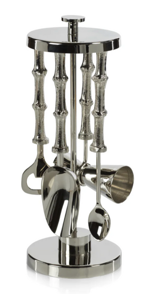 Set of silver kitchen utensils on a cylindrical stand with bamboo-like design on a white background