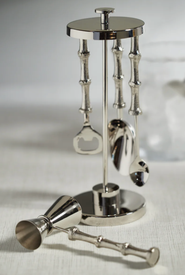 Set of silver cocktail shakers and tools on a white background