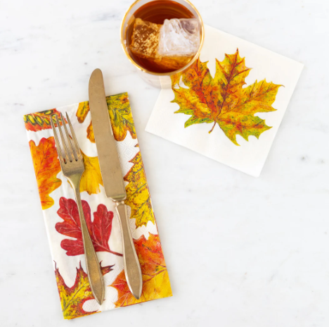 Napkin with autumn leaf design featuring a fork, knife, and cup on a white background