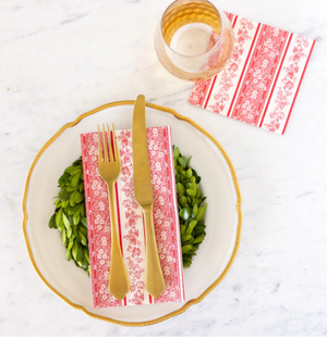 Dinner setting with gold fork, knife, and plate on a white marble surface.