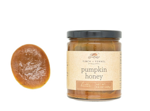 Jar of pumpkin honey with a spreadable sample on a white background