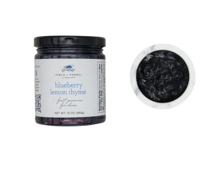 Jar of blueberry lemon thyme fruit preserve with a close-up of the contents on a white background