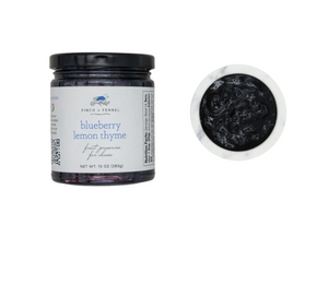 Jar of blueberry lemon thyme fruit preserve with a close-up of the contents on a white background