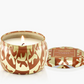 Candle in a decorative container with a pattern on a white background