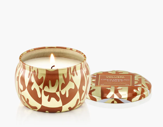 Candle in a decorative container with a pattern on a white background