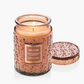 Candle in a decorative jar with a lid, featuring the Voluspa brand.