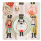 Table setting with nutcracker-themed placemats and cutlery on a striped tablecloth.