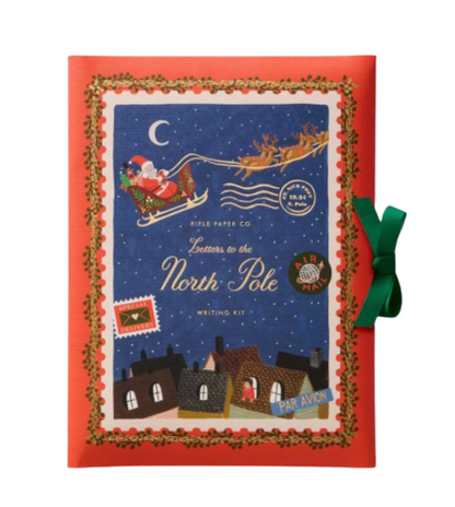 Christmas-themed writing kit with Santa Claus and reindeer on a blue background, framed by holly leaves and a green bow.