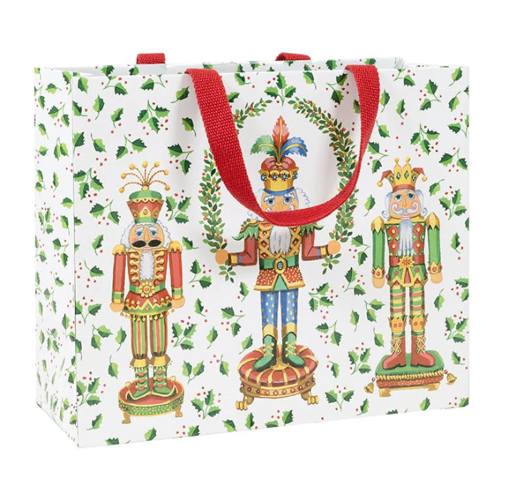 Gift bag with nutcracker design and red handles on a white background