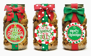 Three jars of cookies with Christmas-themed labels and ribbons on a white background