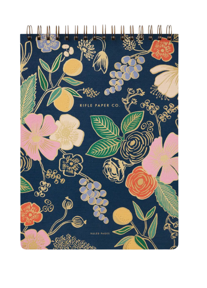 Floral notebook with a blue background and visible brand 'Rifle Paper Co'.