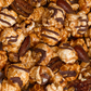 Close-up of caramel popcorn with nuts and chocolate drizzle