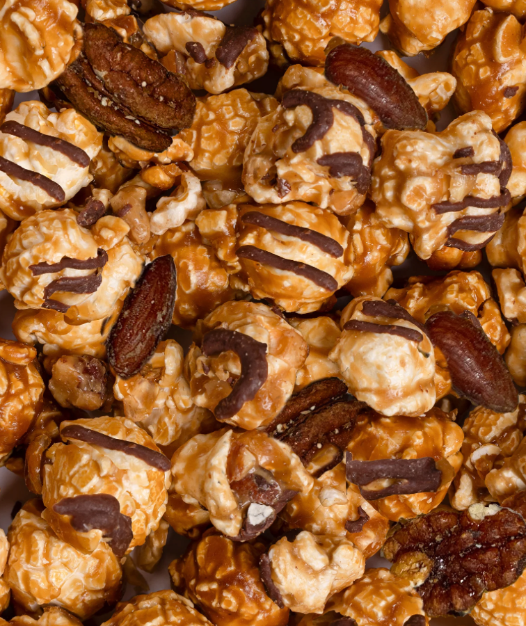 Close-up of caramel popcorn with nuts and chocolate drizzle