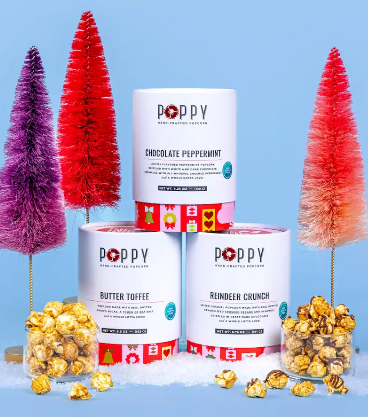 Poppy popcorn containers with Christmas trees and popcorn on a blue background