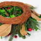 Decorative wreath with greenery, red berries, and brown leaves on a white background