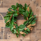 Green and brown leaf wreath on a wooden background