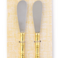 Two bamboo spreaders with gold accents in packaging on a white background